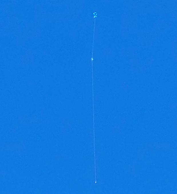 a thin white line with a dot on the bottom and a puffy blue item at the top